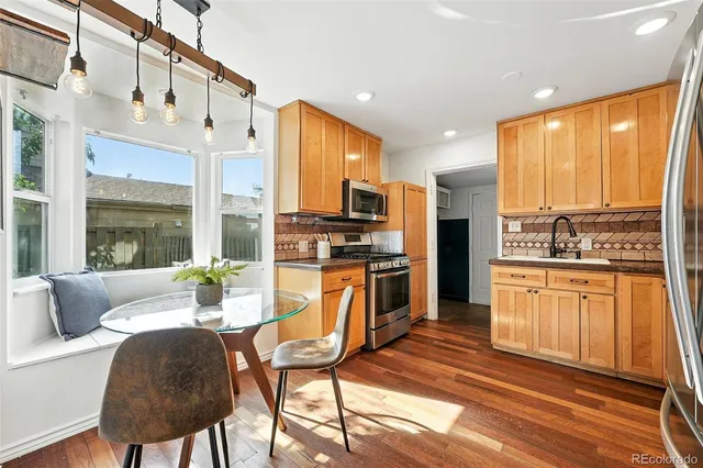 a kitchen with stainless steel appliances granite countertop a refrigerator a stove and a sink with granite countertops