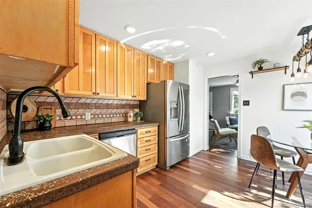 a kitchen with refrigerator cabinets and wooden floor