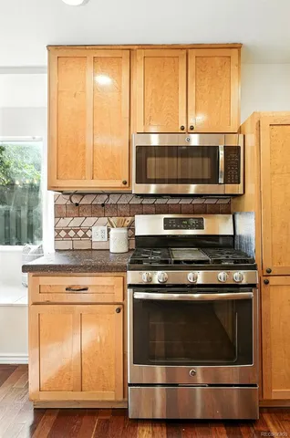 a kitchen with granite countertop cabinets stainless steel appliances and a sink