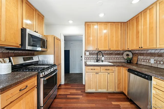 a kitchen with stainless steel appliances a stove sink microwave and cabinets