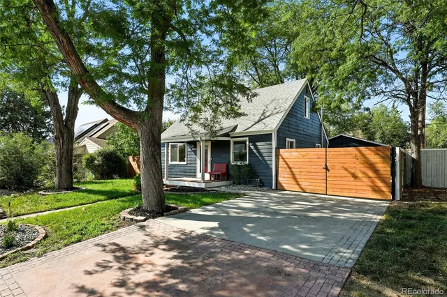 a view of a house with backyard and a tree