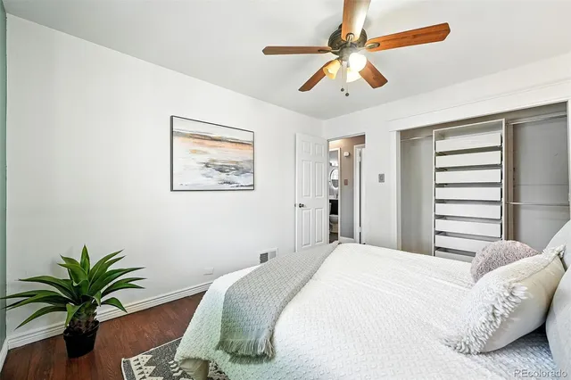 a bedroom with a large bed and a potted plant