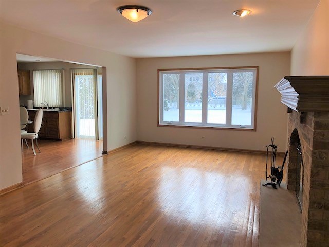 8725 West Sunset Road Niles, IL 60714 - Photo 4 of 15 an empty room with wooden floor and windows