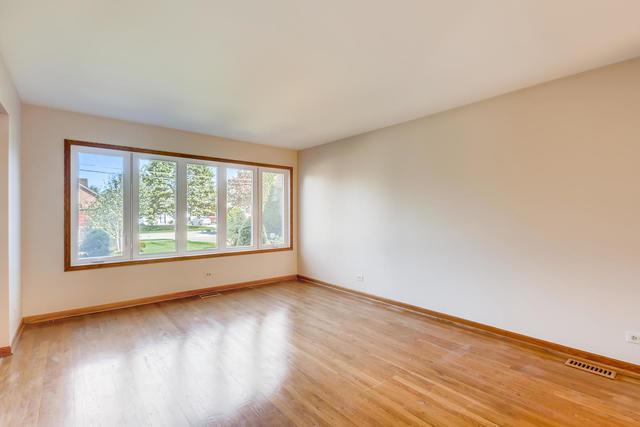 8725 West Sunset Road Niles, IL 60714 - Photo 6 of 15 a view of an empty room with wooden floor and a window