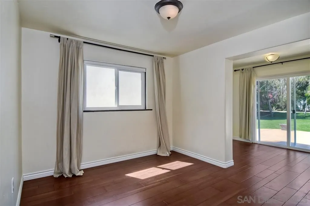 856 Capri Road Encinitas, CA 92024 - Photo 12 of 25 an empty room with wooden floor and windows
