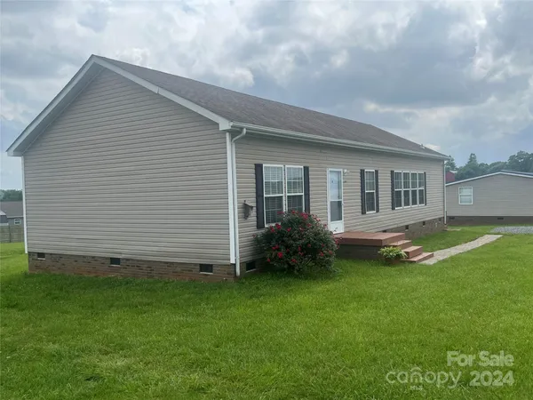 a view of a house with a backyard and a garden