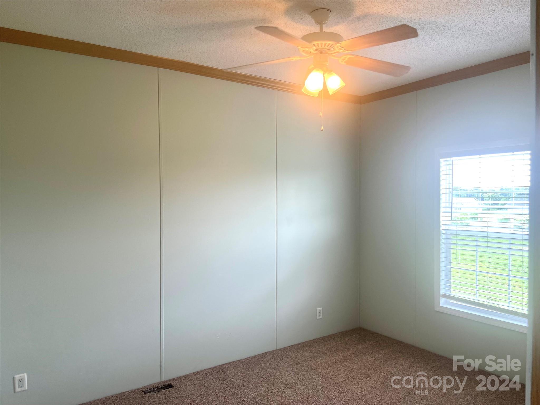 200 Olin Road Olin, NC 28660 - Photo 6 of 17 an empty room with a window and a fan