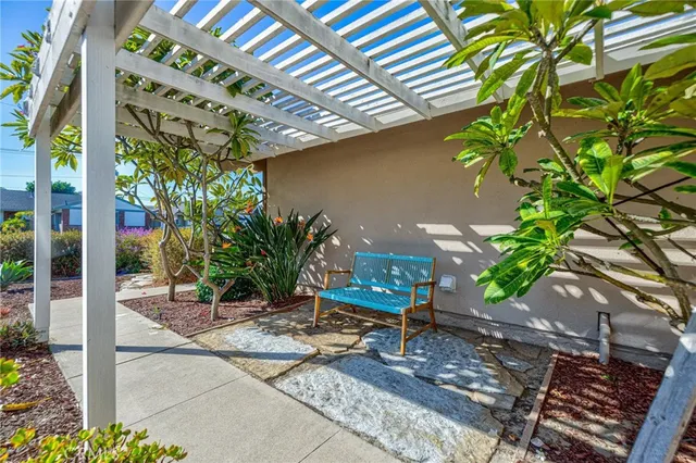 a view of a patio with table and chairs potted plants and floor to ceiling window
