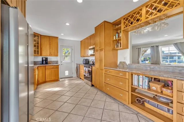 a kitchen with stainless steel appliances kitchen island granite countertop a refrigerator and cabinets