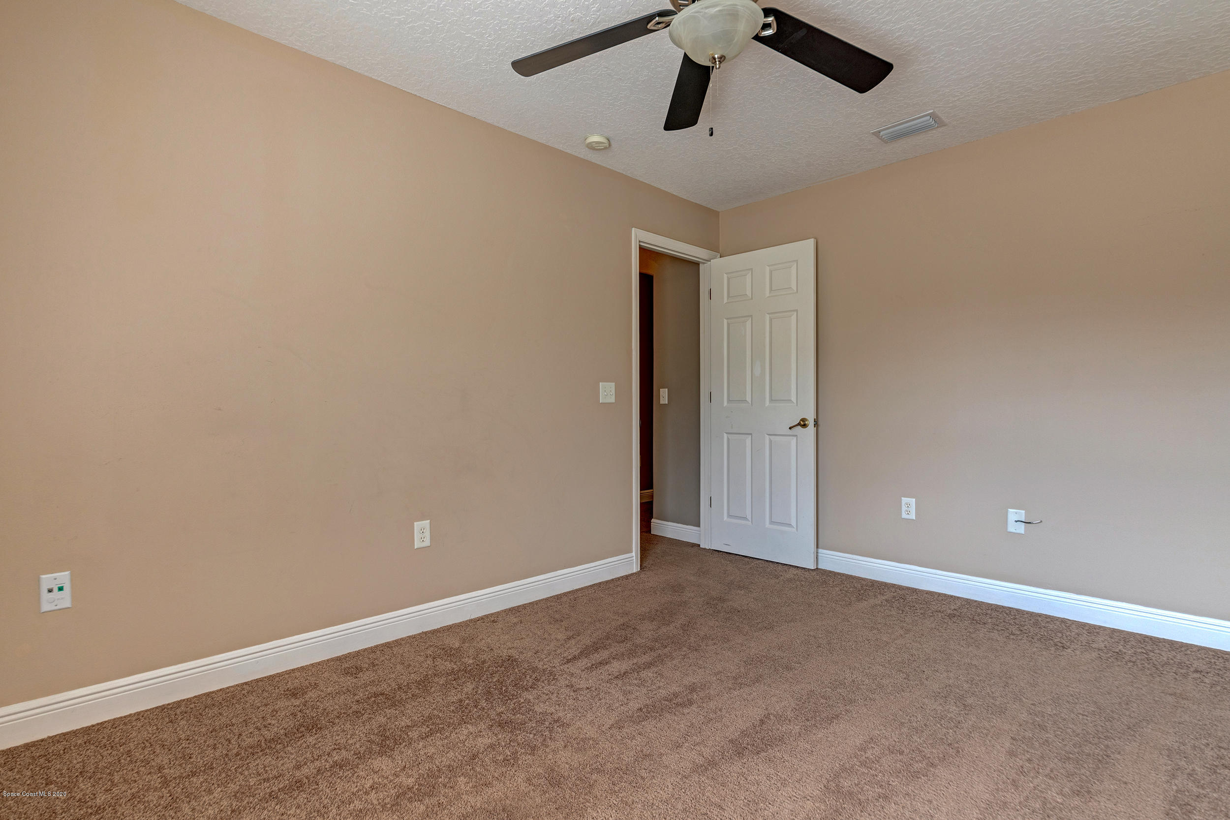 1306 Scranton Street Southwest Palm Bay, FL 32908 - Photo 13 of 36 an empty room with ceiling fan and window