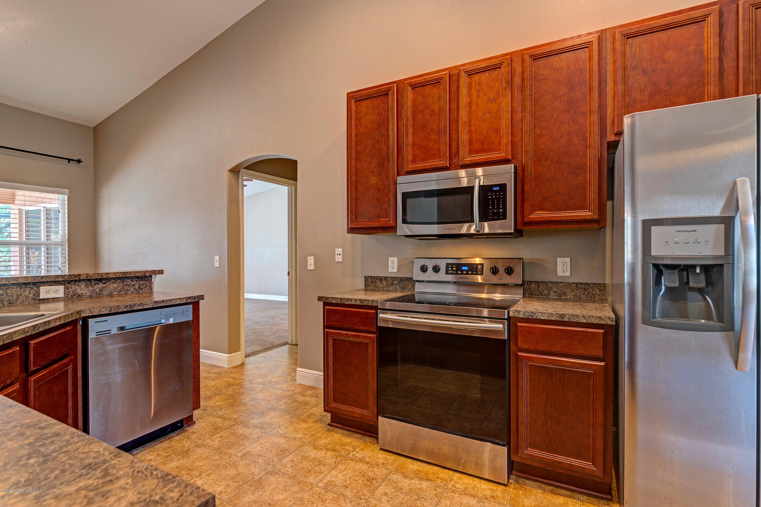 1306 Scranton Street Southwest Palm Bay, FL 32908 - Photo 23 of 36 a kitchen with stainless steel appliances granite countertop a stove top oven and sink