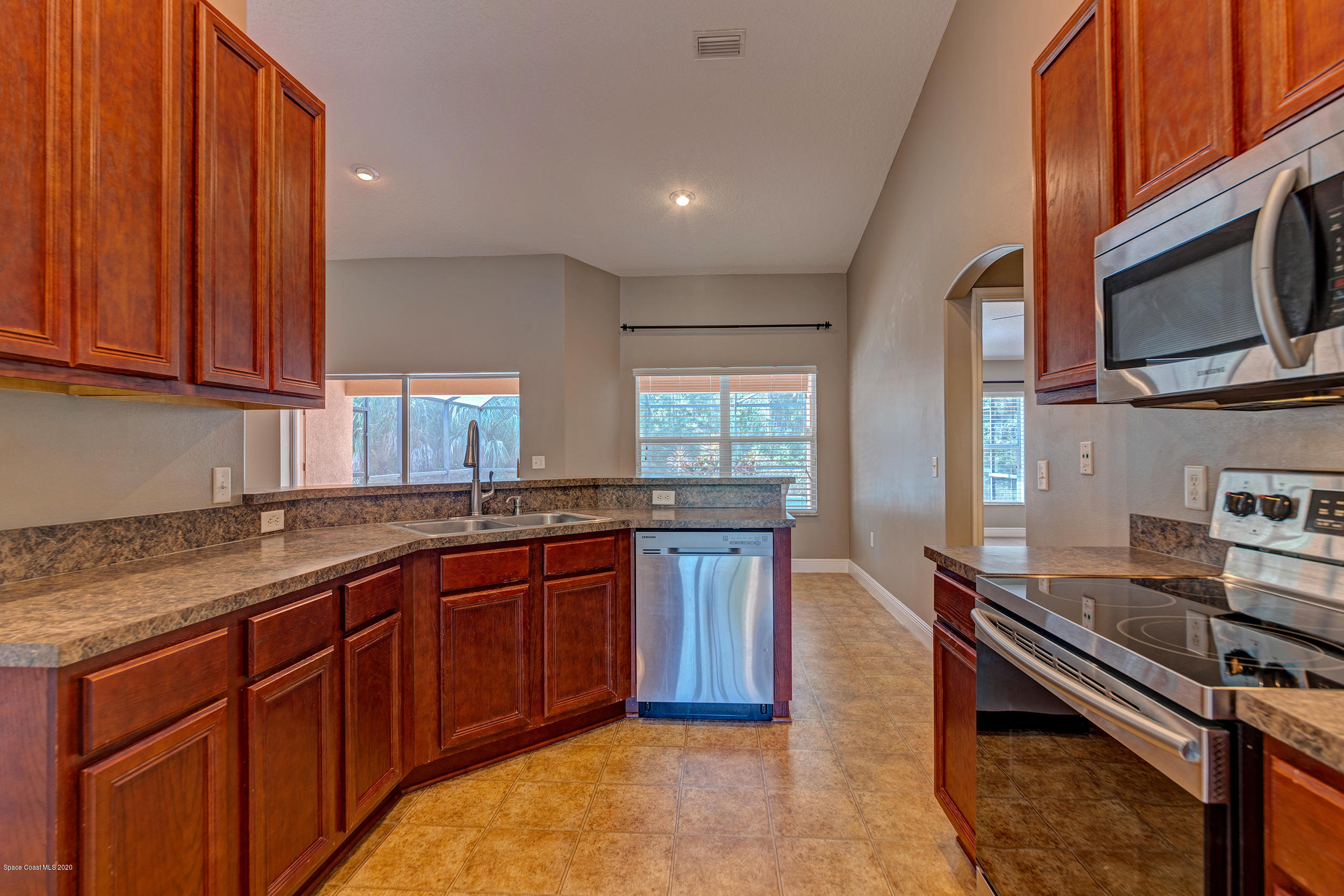 1306 Scranton Street Southwest Palm Bay, FL 32908 - Photo 24 of 36 a kitchen with stainless steel appliances granite countertop a stove microwave and sink