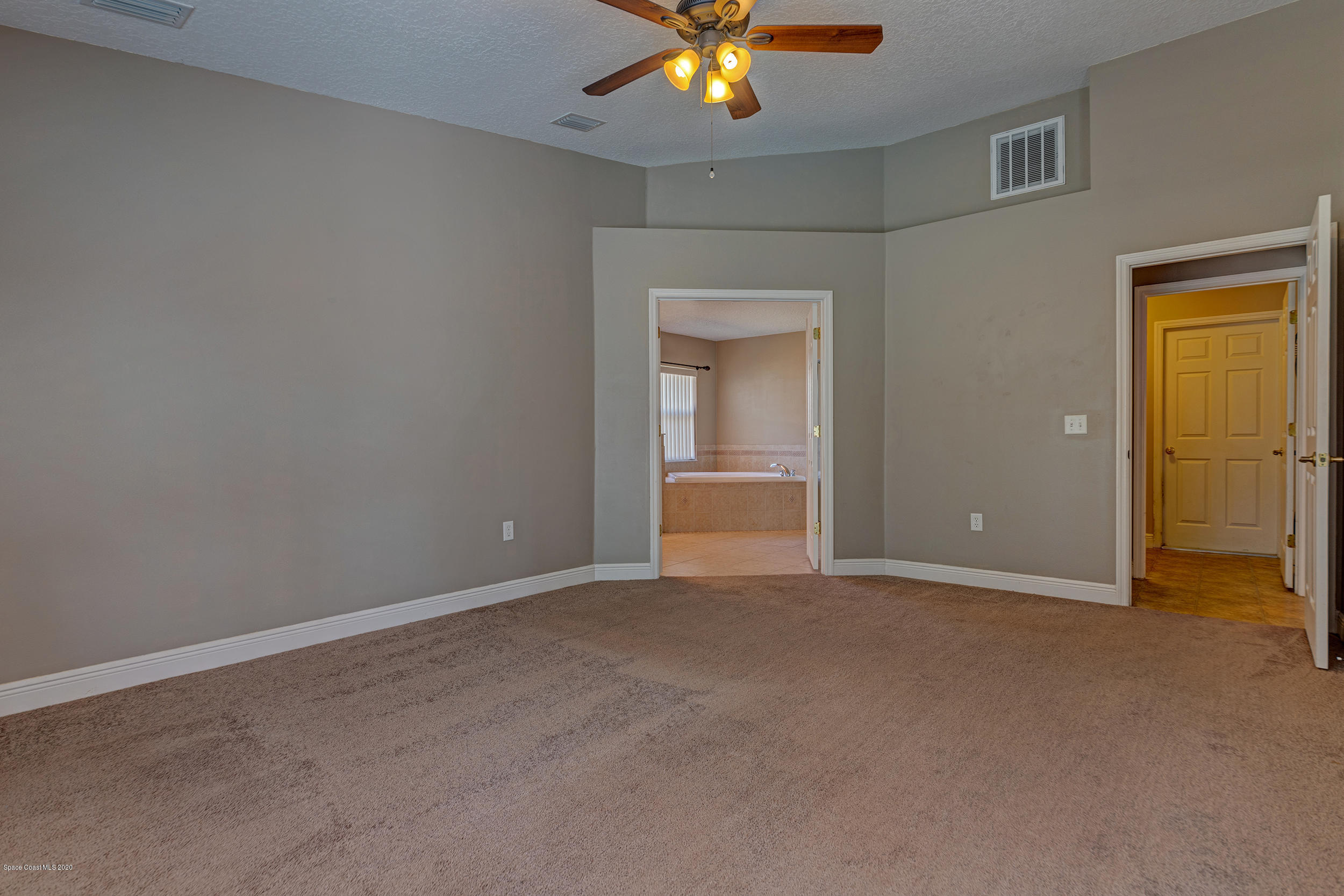 1306 Scranton Street Southwest Palm Bay, FL 32908 - Photo 27 of 36 a view of an empty room with a chandelier fan and a fireplace