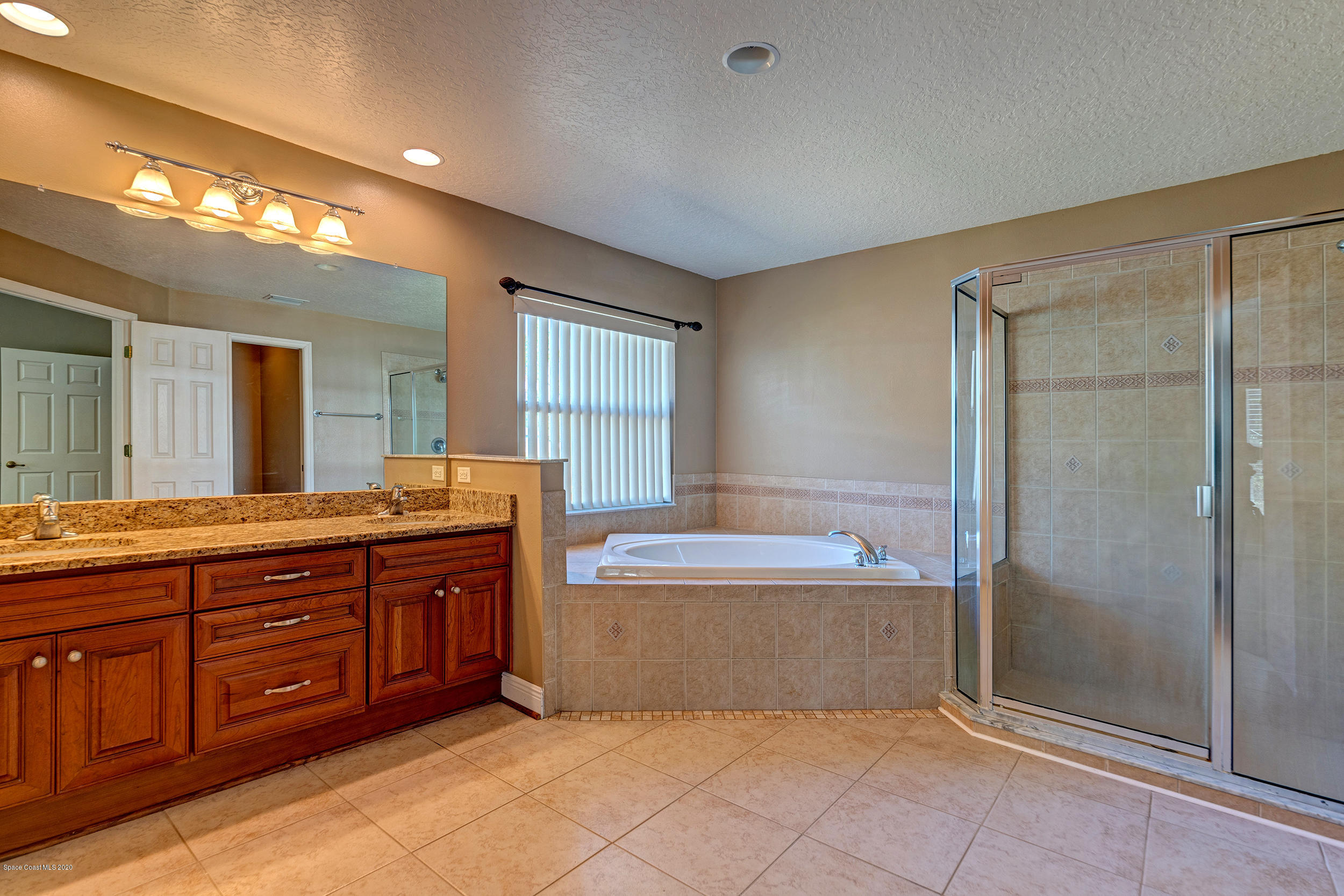 1306 Scranton Street Southwest Palm Bay, FL 32908 - Photo 29 of 36 a spacious bathroom with a tub sink and mirror