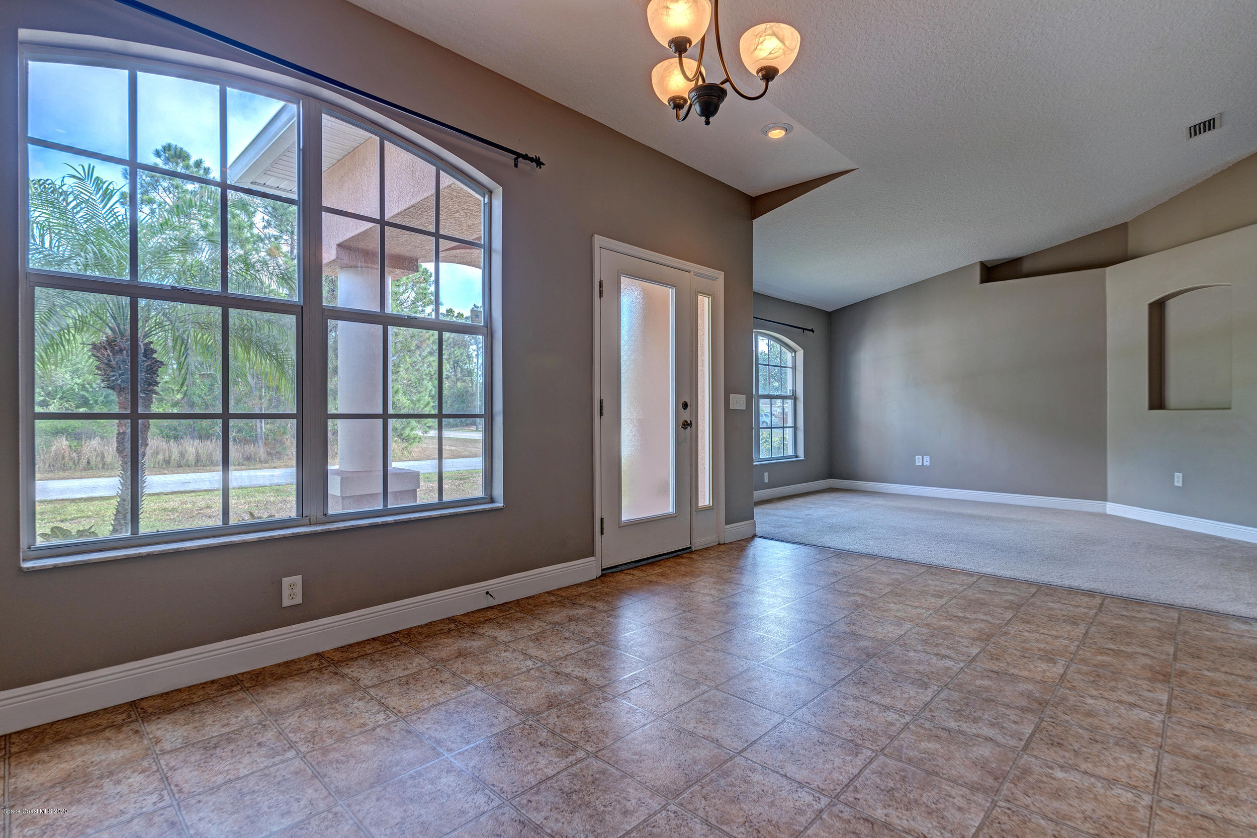 1306 Scranton Street Southwest Palm Bay, FL 32908 - Photo 4 of 36 a view of an empty room with a window and wooden floor