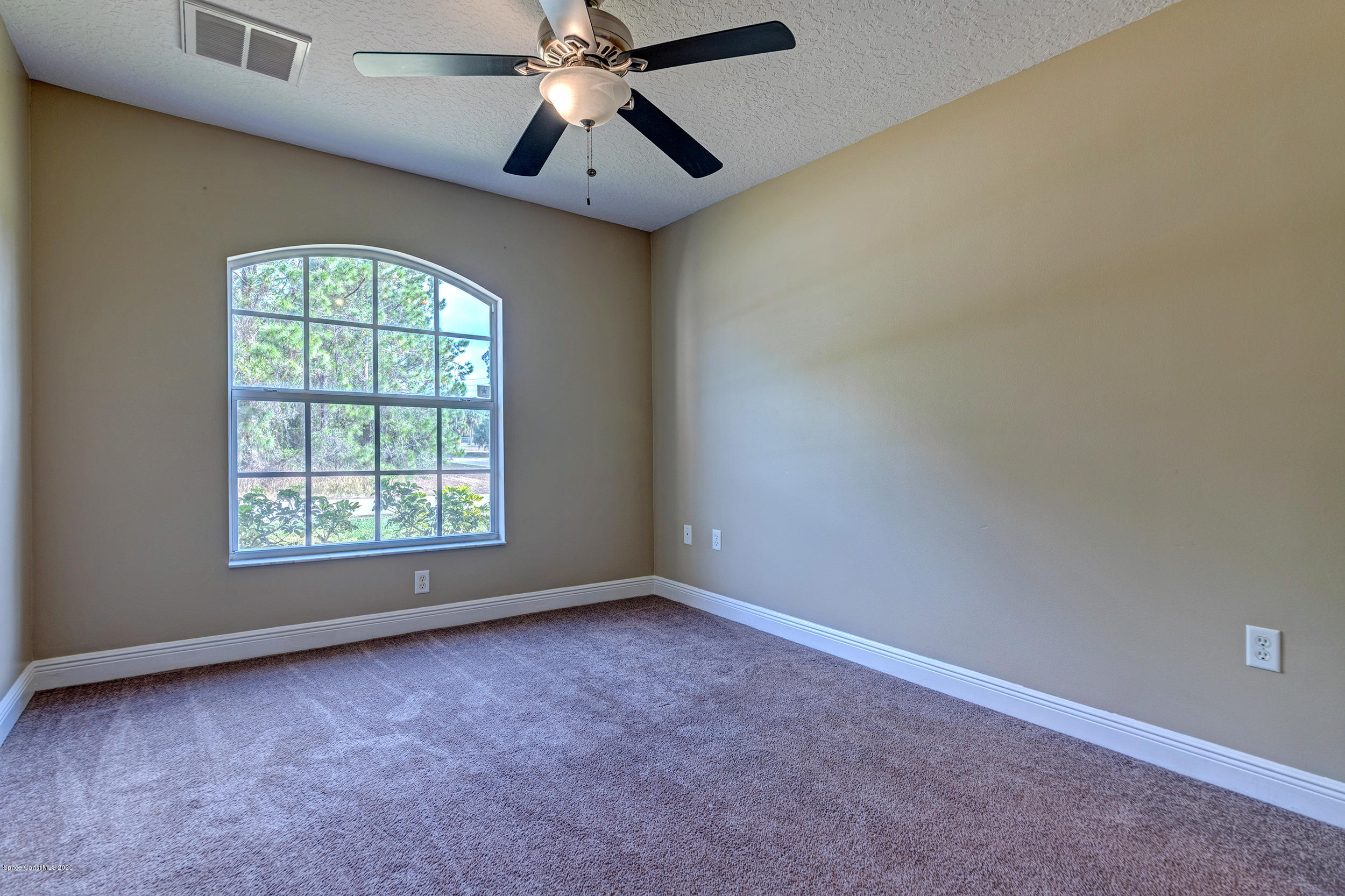 1306 Scranton Street Southwest Palm Bay, FL 32908 - Photo 9 of 36 an empty room with a window and a fan