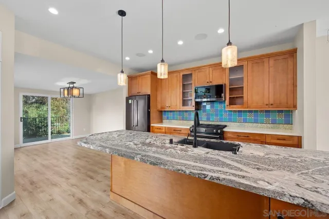 a kitchen with stainless steel appliances granite countertop a sink a stove and a granite counter tops