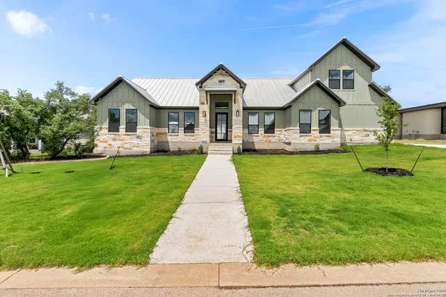 a front view of a house with a yard and trees