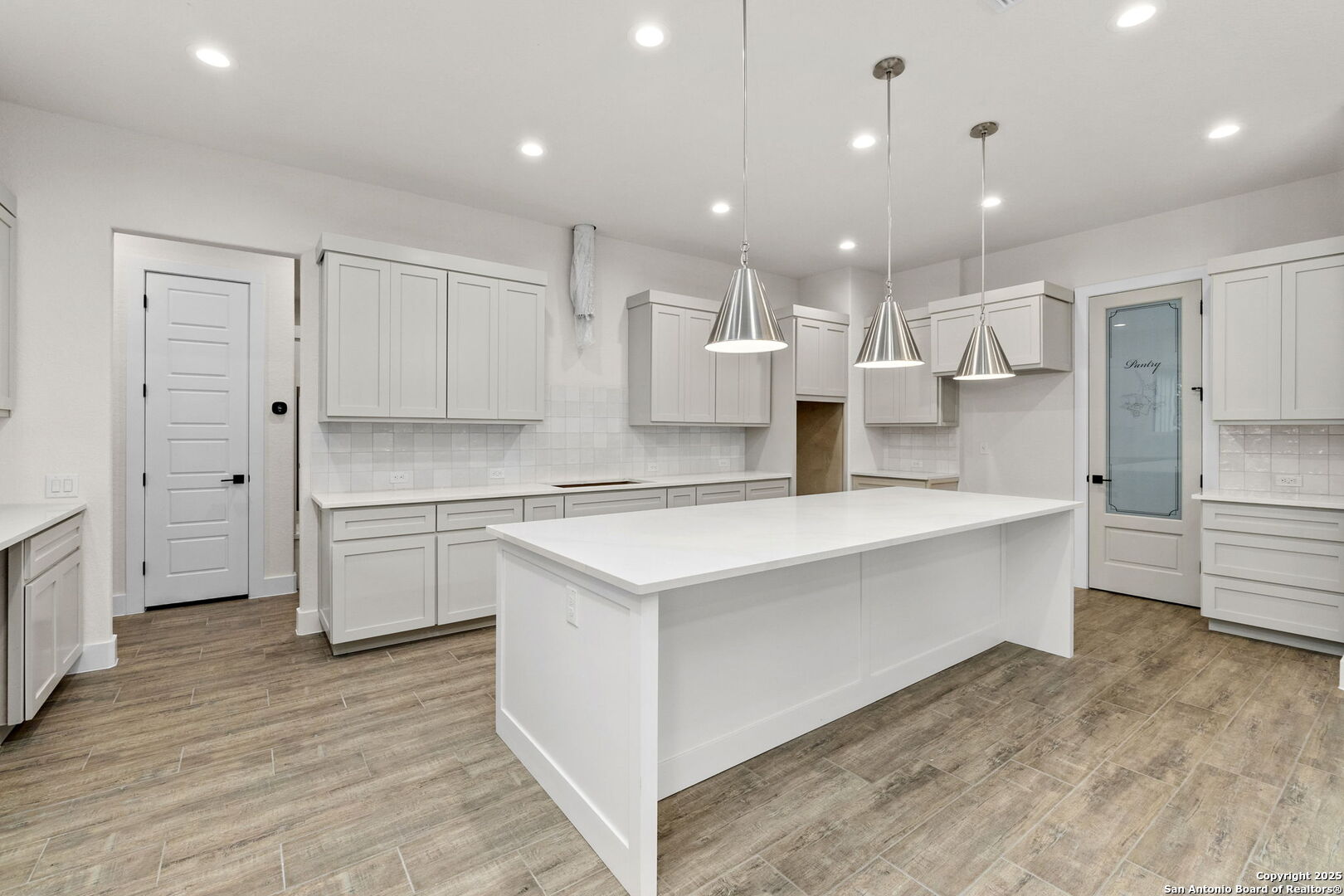 32 Peace Pipe Wimberley, TX 78676 - Photo 6 of 9 a large white kitchen with kitchen island a sink a stove a refrigerator and white cabinets