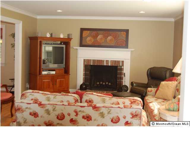 25 Woodhollow Road Colts Neck, NJ 07722 - Photo 3 of 3 a living room with furniture a fireplace and a flat screen tv