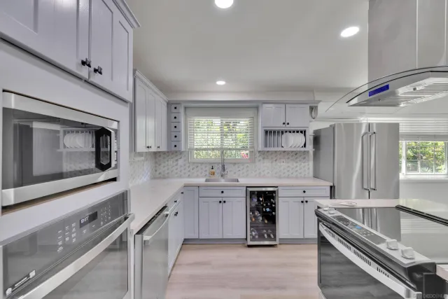 a kitchen with stainless steel appliances granite countertop a stove a sink and a microwave