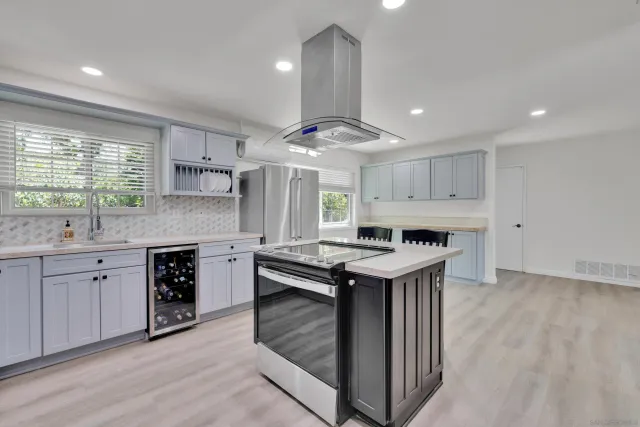 a kitchen with a stove sink and cabinets