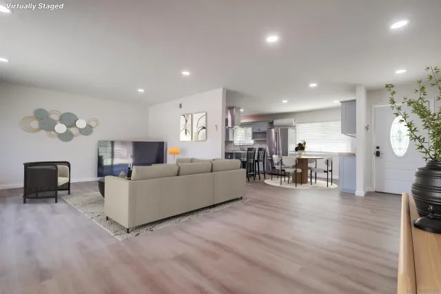a living room with furniture and a wooden floor