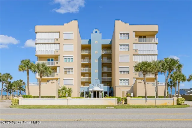 a front view of a multi story residential apartment building with yard