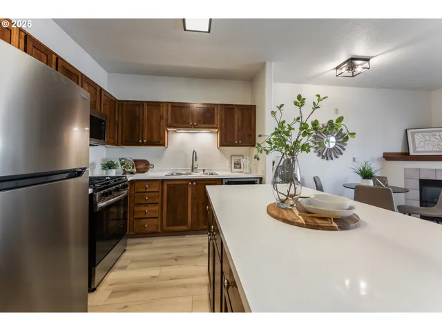 a kitchen with kitchen island granite countertop stainless steel appliances a sink a stove and refrigerator