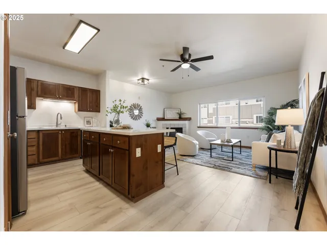 a living room with stainless steel appliances kitchen island granite countertop a sink a stove a dining table with rug