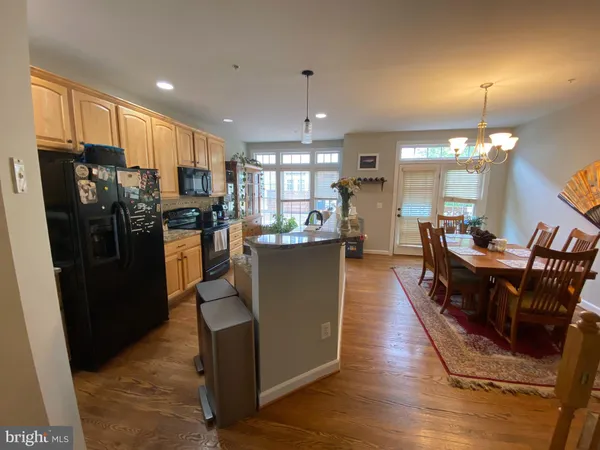 a kitchen with stainless steel appliances granite countertop a refrigerator a stove top oven a sink dishwasher and wooden floor