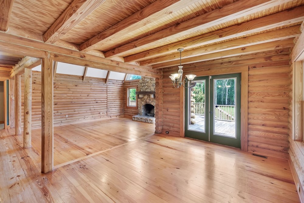 414 Devon Way Anderson, SC 29621 - Photo 9 of 50 A spacious log cabin living area features natural wood finishes and a stately stone fireplace.