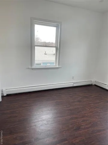 an empty room with wooden floor and closet