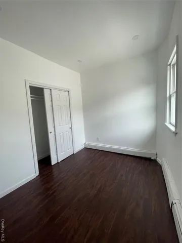 an empty room with wooden floor and closet