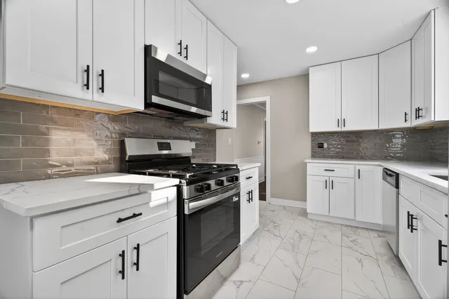a kitchen with granite countertop a stove top oven microwave and cabinets