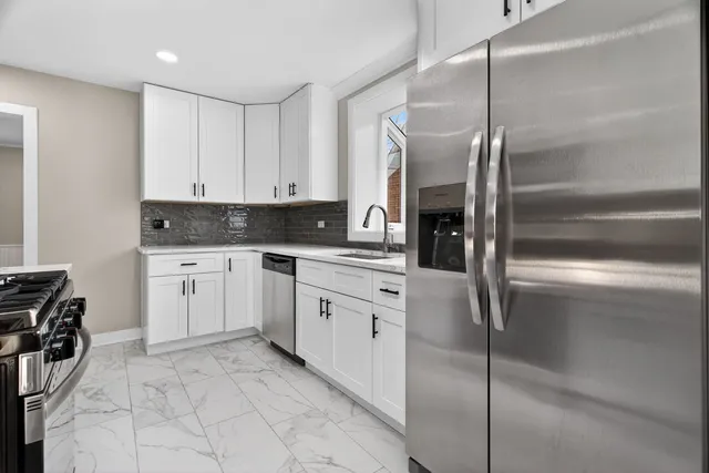 a kitchen with white cabinets and white appliances