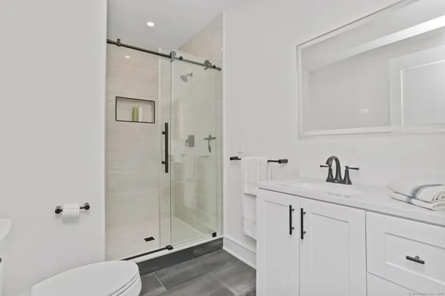a bathroom with a granite countertop sink toilet and shower
