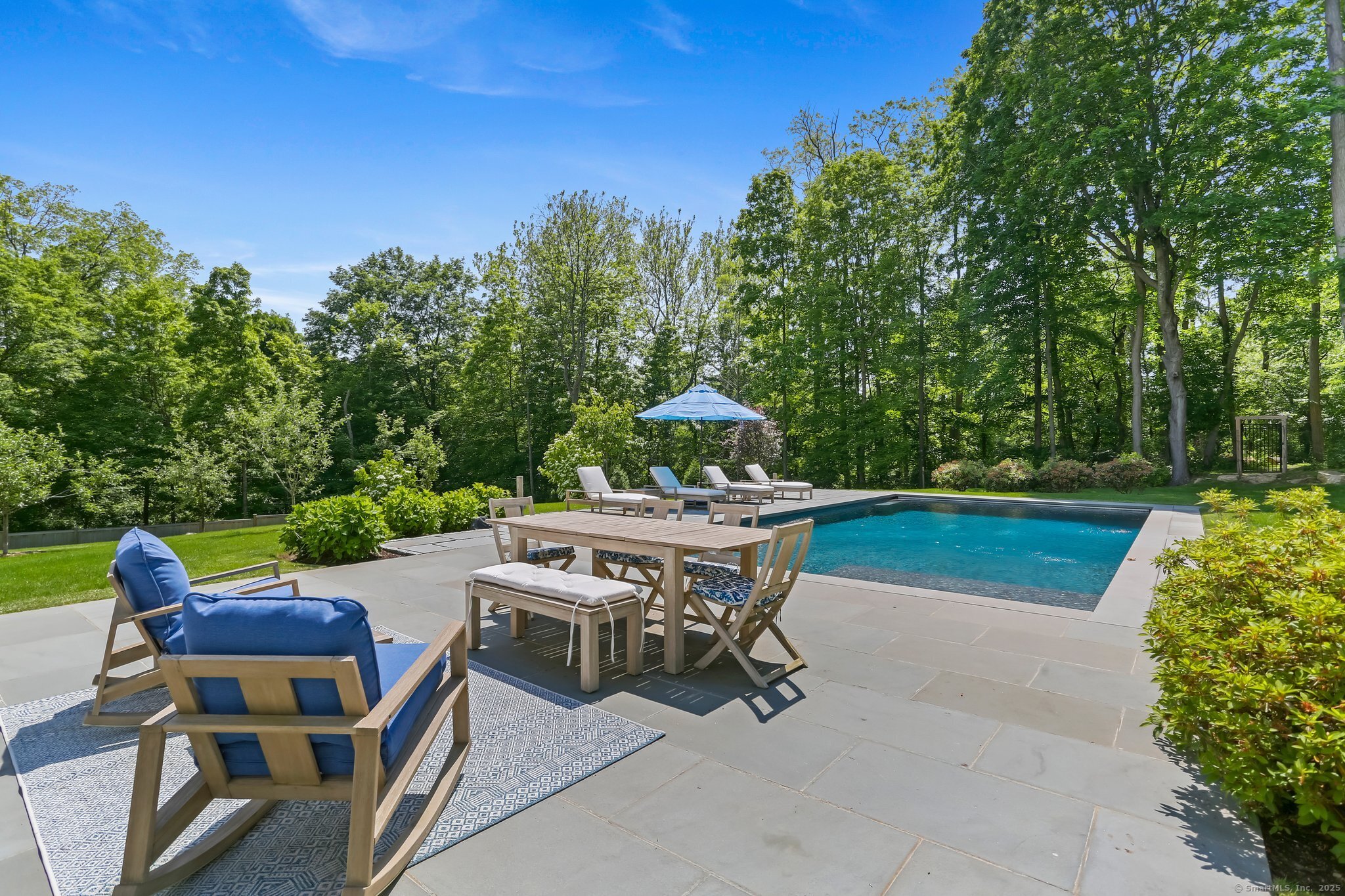 2015 Redding Road Fairfield, CT 06824 - Photo 36 of 40 a view of a patio with table and chairs and a barbeque with potted plants and large trees