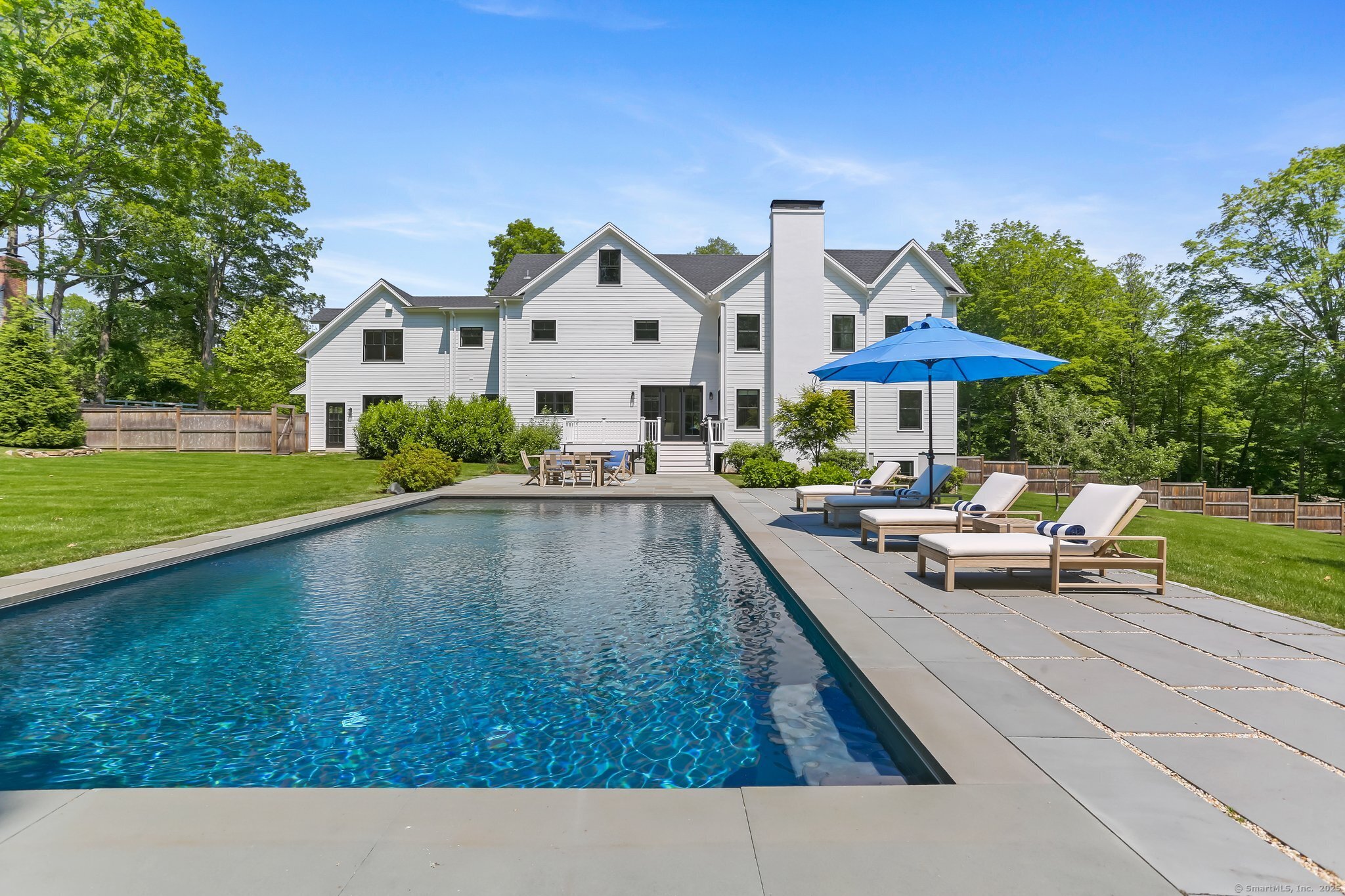 2015 Redding Road Fairfield, CT 06824 - Photo 39 of 40 a view of swimming pool with lounge chair and dinning table under an umbrella