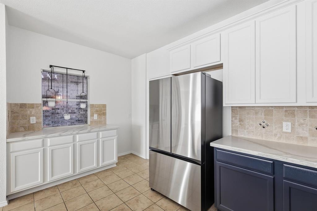 6000 Lost Valley Drive The Colony, TX 75056 - Photo 14 of 40 a kitchen with white cabinets and refrigerator