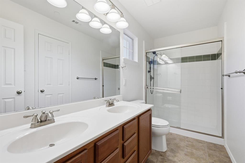 6000 Lost Valley Drive The Colony, TX 75056 - Photo 24 of 40 a bathroom with a double vanity sink mirror and toilet