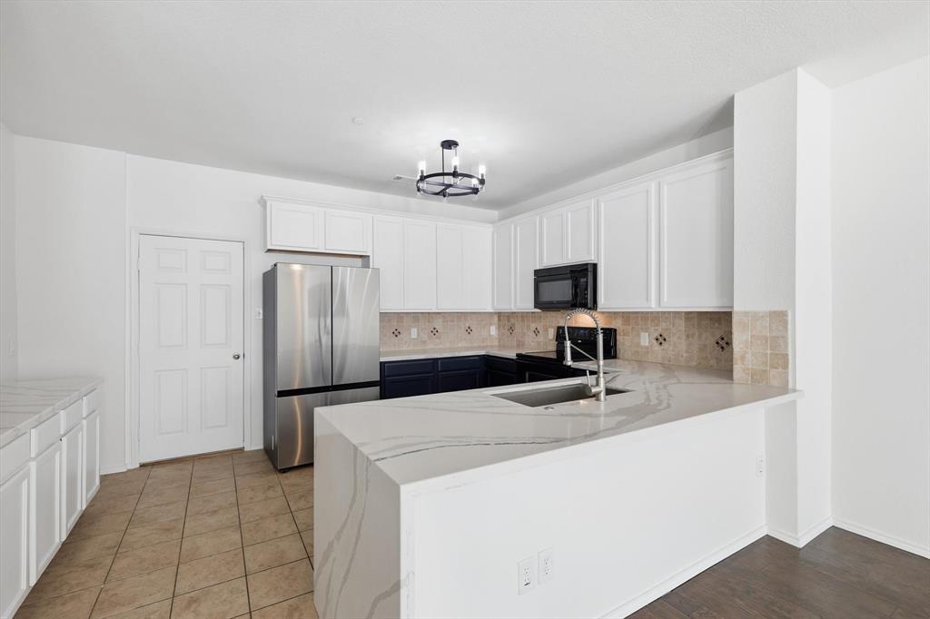 6000 Lost Valley Drive The Colony, TX 75056 - Photo 9 of 40 a kitchen with stainless steel appliances a refrigerator sink and microwave