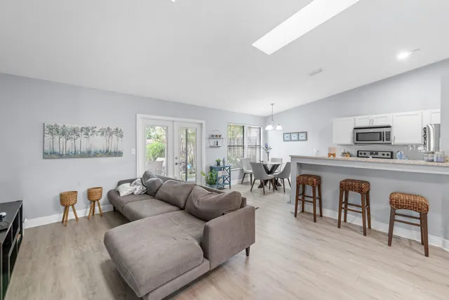 a living room with furniture a kitchen view and a fireplace