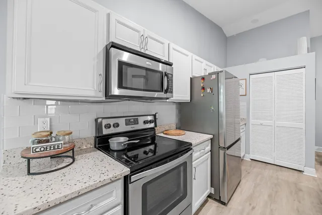 a kitchen with stainless steel appliances granite countertop a stove and a refrigerator