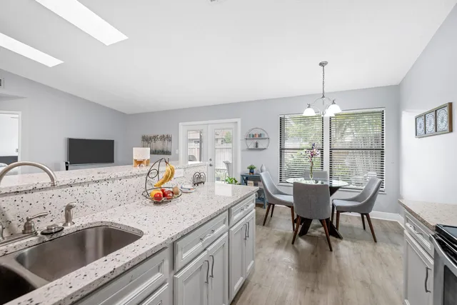 a kitchen with a table chairs and wooden floor