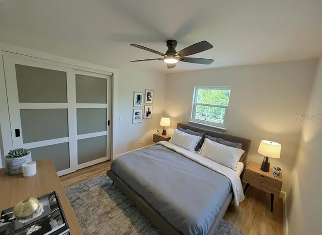 a bedroom with a bed and a table with wooden floor