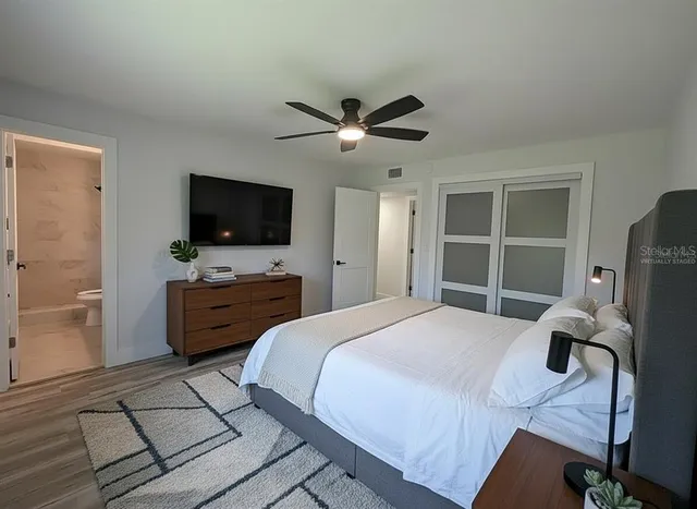a bedroom with a bed flat screen tv and a dresser