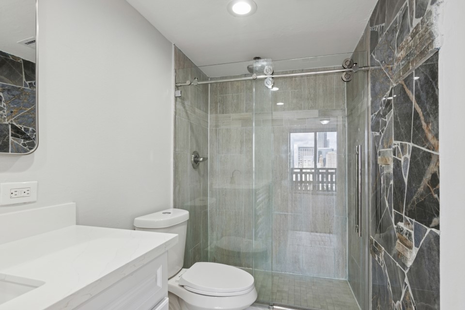 2016 Main Street, Unit 2507 Houston, TX 77002 - Photo 15 of 32 a bathroom with a shower a toilet and a sink