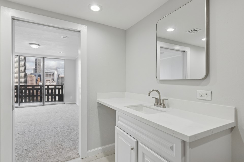 2016 Main Street, Unit 2507 Houston, TX 77002 - Photo 16 of 32 a bathroom with a sink vanity and a mirror