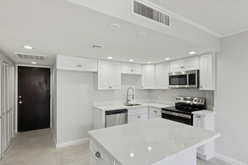 2016 Main Street, Unit 2507 Houston, TX 77002 - Photo 7 of 32 a kitchen with a sink stainless steel appliances and white cabinets